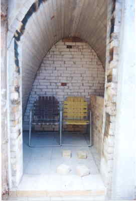 Wood kiln with lawn chairs for pre-firing sauna